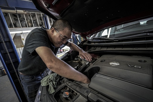 A team member carefully inspecting a vehicle engine at Gear Flux, symbolizing precision and dedication to quality.